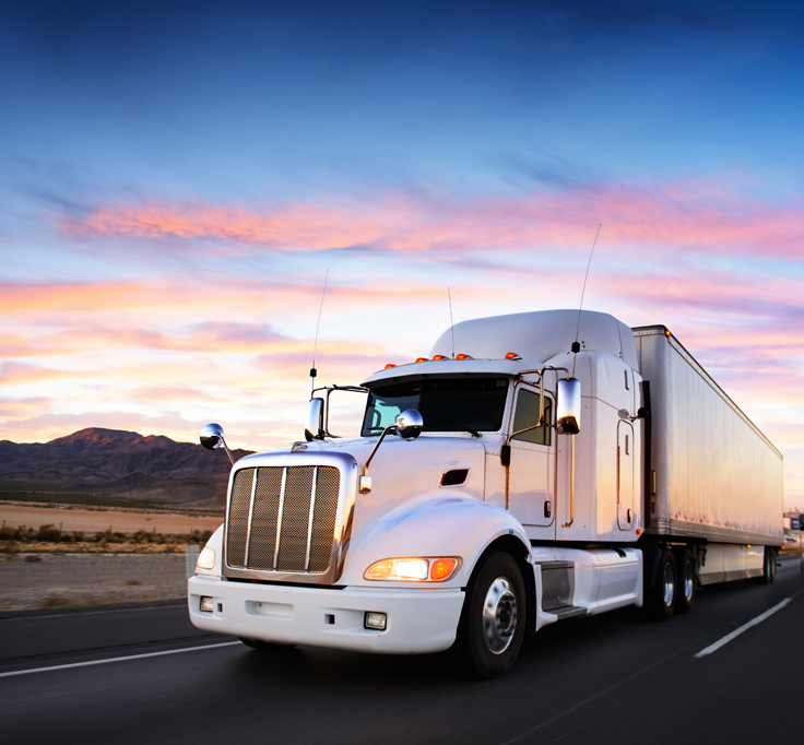 white tractor trailer driving at sunset
