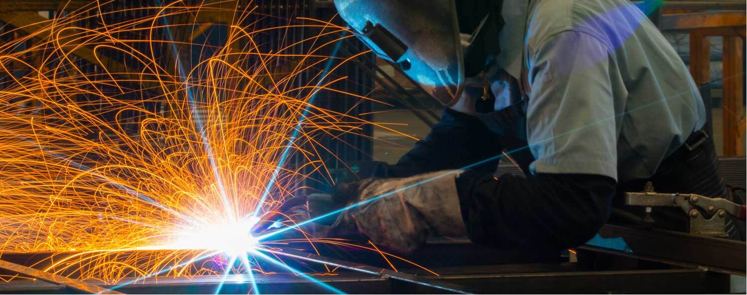 Image of welder in action with bright welding light and sparks