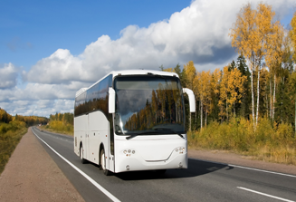 Image of a black and white commercial bus driving on a road