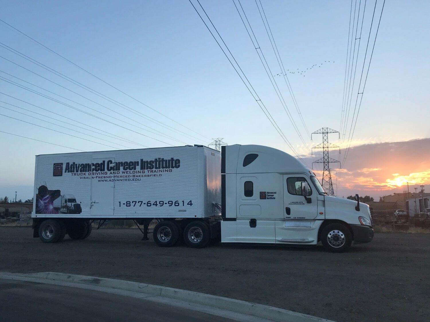 ACI semi truck parked in training yard with a sunset in background