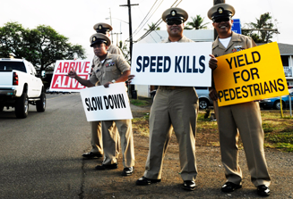 image of cops standing on side of road with signs about safe driving