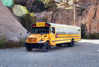 image of school bus parked next to mountains