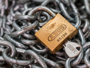 image of metal chains and a lock with a key inserted