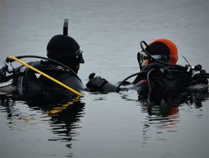 image of two people in diving gear standing in water