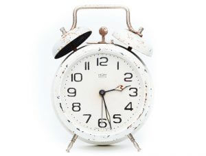 image of old-fashioned, slightly rusted, white alarm clock