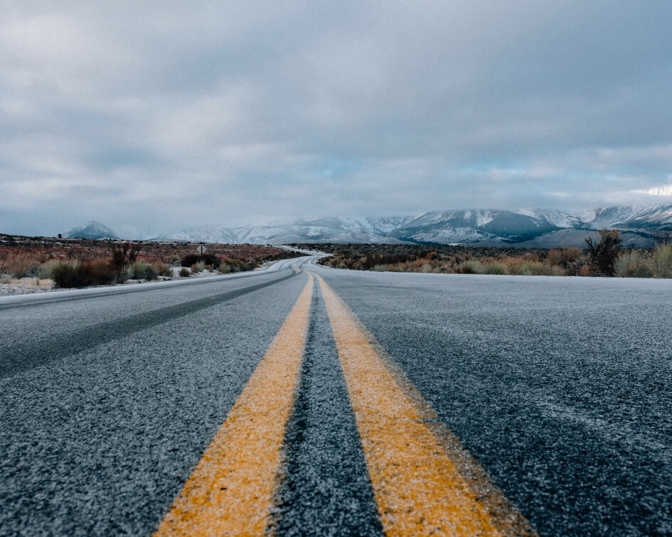 image of empty road, a thin layer of snow on the ground, taken from a low angle