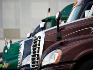 Image of different colored semi-truck cabs lined up next to each other