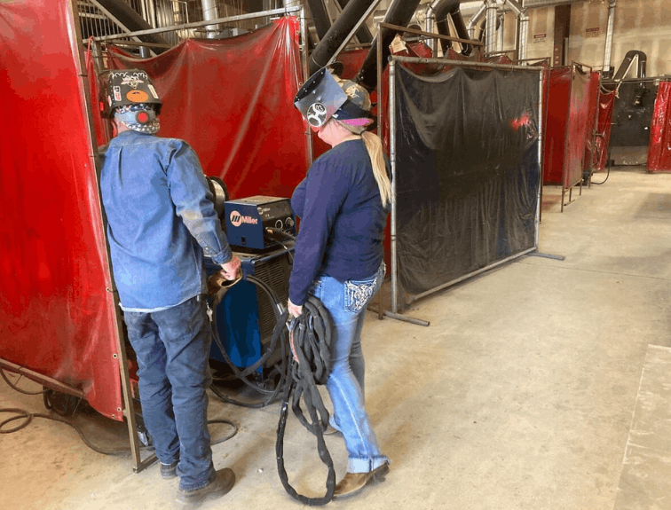 Students discussing in a welding lab